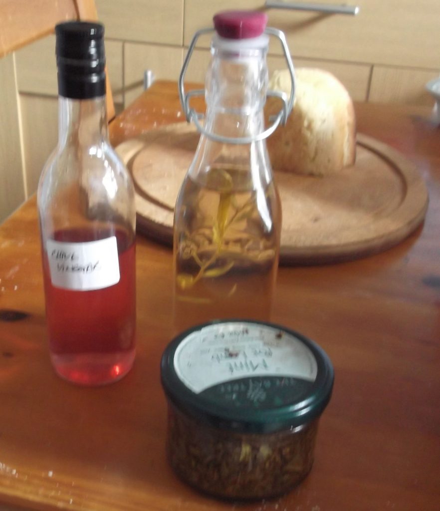 bottles of tarragon and chive flower vinegar, jar of mint sauce