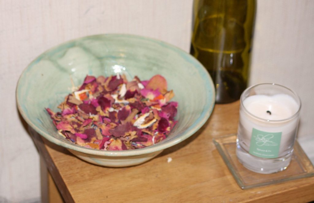 a bowl of pot pourri and a candle